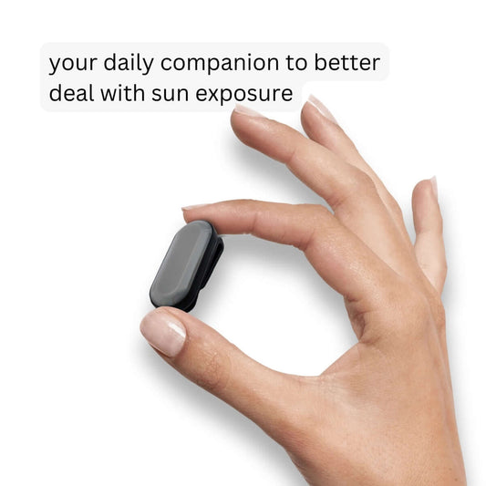 Human hand holding sun-a-wear UV tracker, depicting its small size, your daily companion to better deal with sun exposure